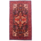Hand-knotted wool pile Persian Nahavand Kelleghi rug with pink and red medallion on a black field with red border. Rug has numerous inscriptions.
