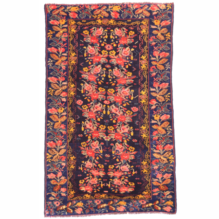 Antique Karabagh rug with floral design set against a blue-black ground.