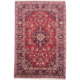 Traditional red and blue Persian Kashan rug with floral medallion design.