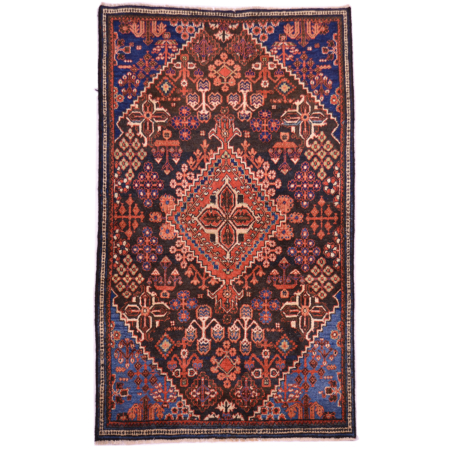 Antique Joshaghan rug with geometric medallion design on a blue-black field with blue corners.